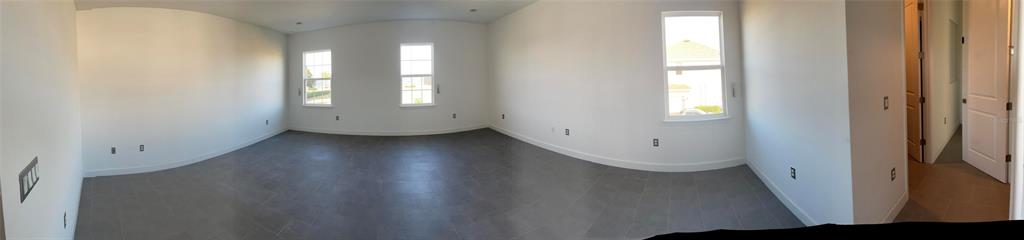 17708 Sawgrass Run Tavares, FL 32778 - Photo 49 of 79 an empty room with wooden floor and windows