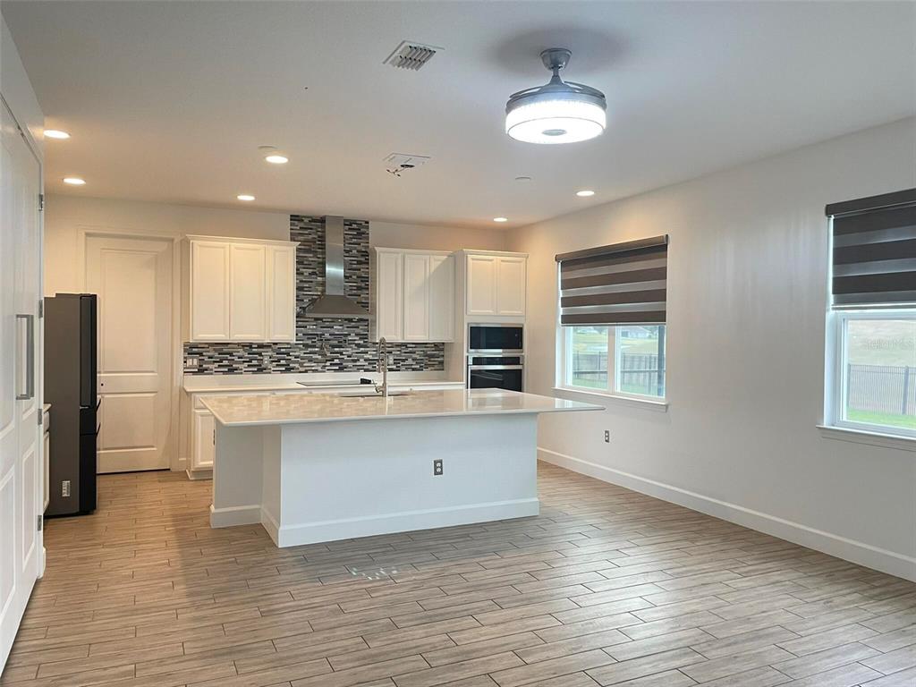 17708 Sawgrass Run Tavares, FL 32778 - Photo 7 of 79 a view of kitchen with granite countertop cabinets and refrigerator