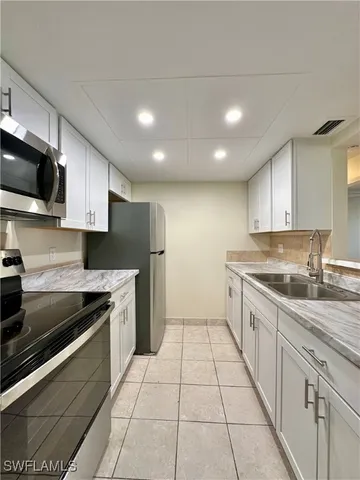 a kitchen with stainless steel appliances granite countertop a sink refrigerator and microwave