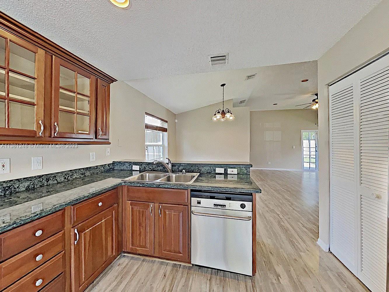 Silver Lakes Miramar, FL 33029 - Photo 9 of 17 a kitchen with stainless steel appliances granite countertop a stove a sink and a granite counter tops with wooden floors