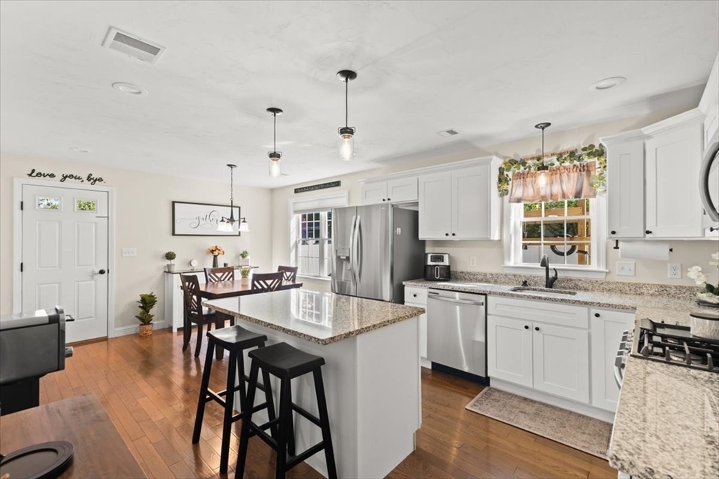 25 Upton Street Hanson, MA 02341 - Photo 9 of 30 a kitchen with stainless steel appliances kitchen island granite countertop a table chairs sink and cabinets