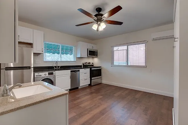 a kitchen with granite countertop a stove a sink and a refrigerator