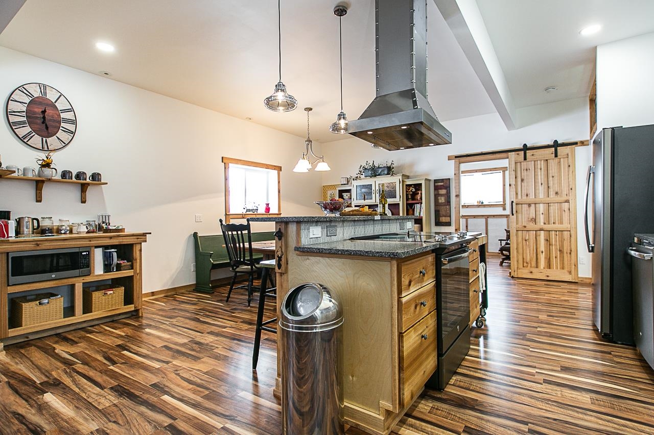 4757 North Hammer Road Scales Mound, IL 61075 - Photo 71 of 95 a kitchen with stainless steel appliances granite countertop a refrigerator a oven a stove and a dining table with wooden floor