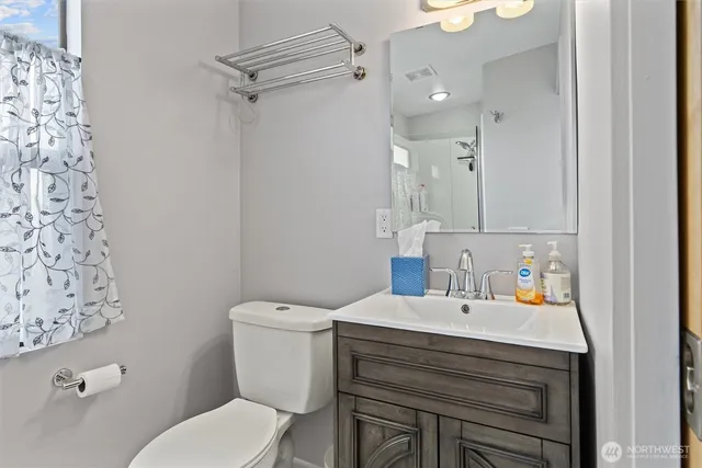a bathroom with a sink vanity mirror and toilet