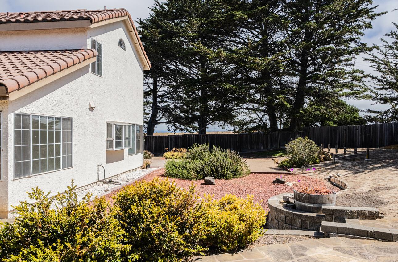 337 Quebrada Del Mar Road Marina, CA 93933 - Photo 19 of 44 a view of a backyard with a large tree and wooden fence