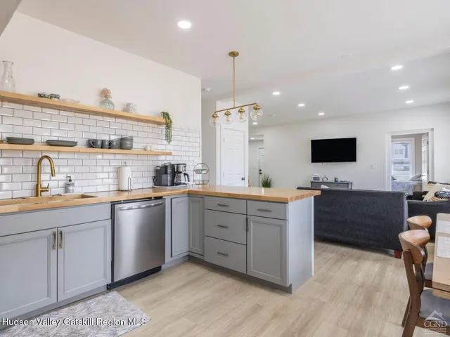 a living room with furniture a flat screen tv and a window