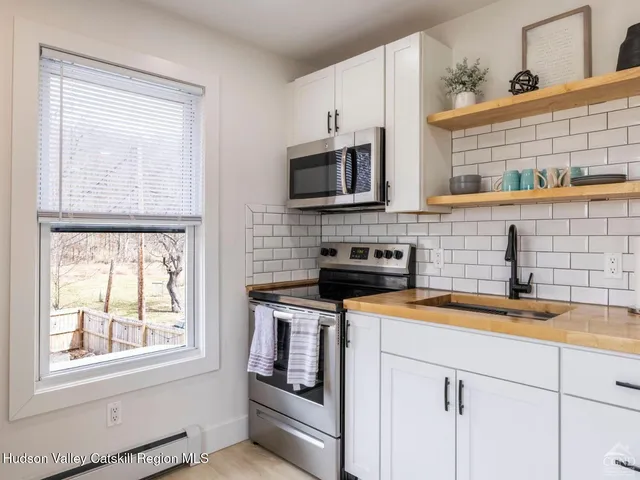 a bedroom with a bed and a lamp on dresser