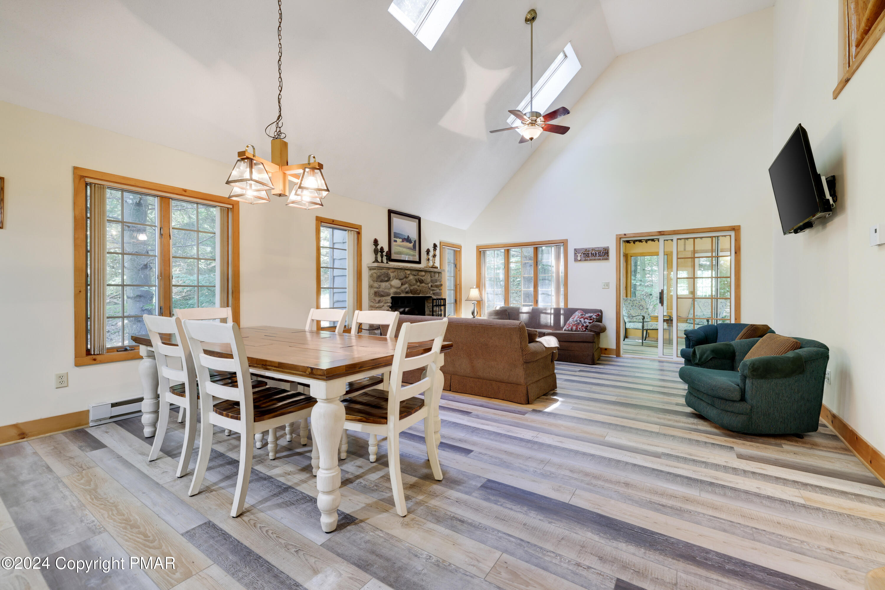 a view of a dining room with furniture a chandelier and wooden floor