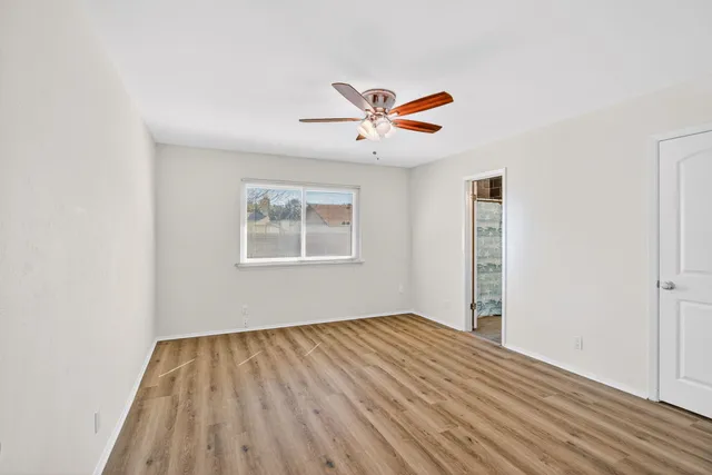 a view of a big room with wooden floor and a ceiling fan