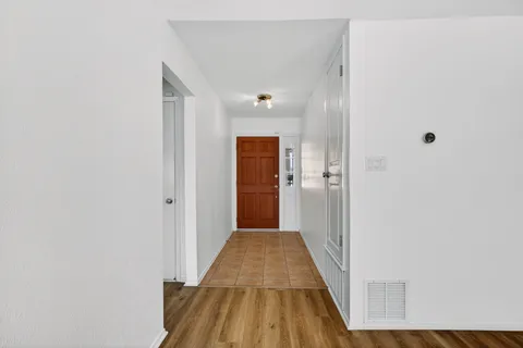 a view of a hallway with wooden floor