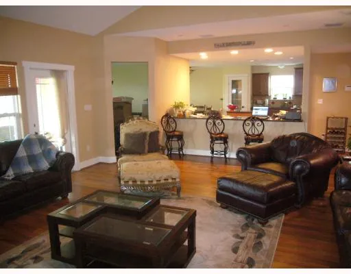 a living room with furniture and a large mirror with wooden floor