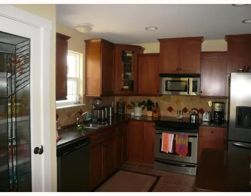 a kitchen with a refrigerator and a stove top oven