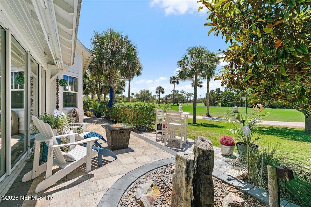 556 Timber Bridge Lane Atlantic Beach, FL 32233 - Photo 24 of 71 a view of a patio with couches chairs potted plants and a palm tree