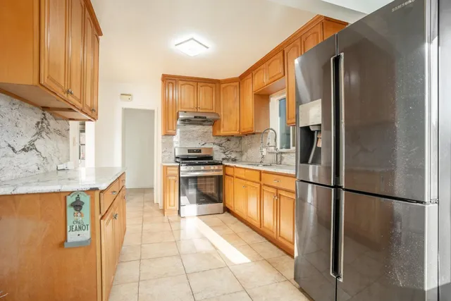 a kitchen with stainless steel appliances granite countertop a refrigerator and a stove