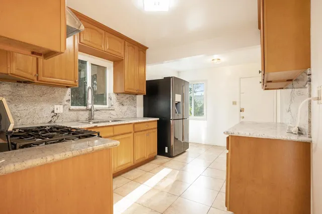 a kitchen with stainless steel appliances granite countertop a refrigerator and a stove