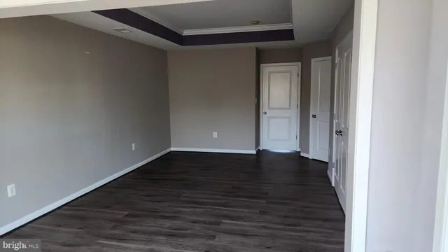 a view of an empty room with wooden floor and closet