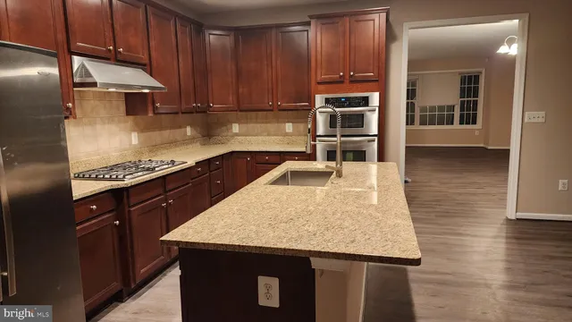 a kitchen with granite countertop a stove a sink and dishwasher
