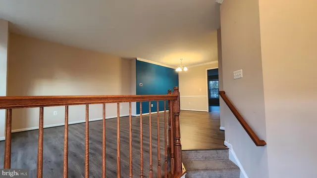 a view of staircase with lots of frames on wall and wooden floor