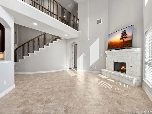 a view of an empty room with stairs and a fireplace
