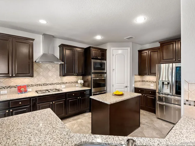 a kitchen with stainless steel appliances granite countertop a sink stove and refrigerator