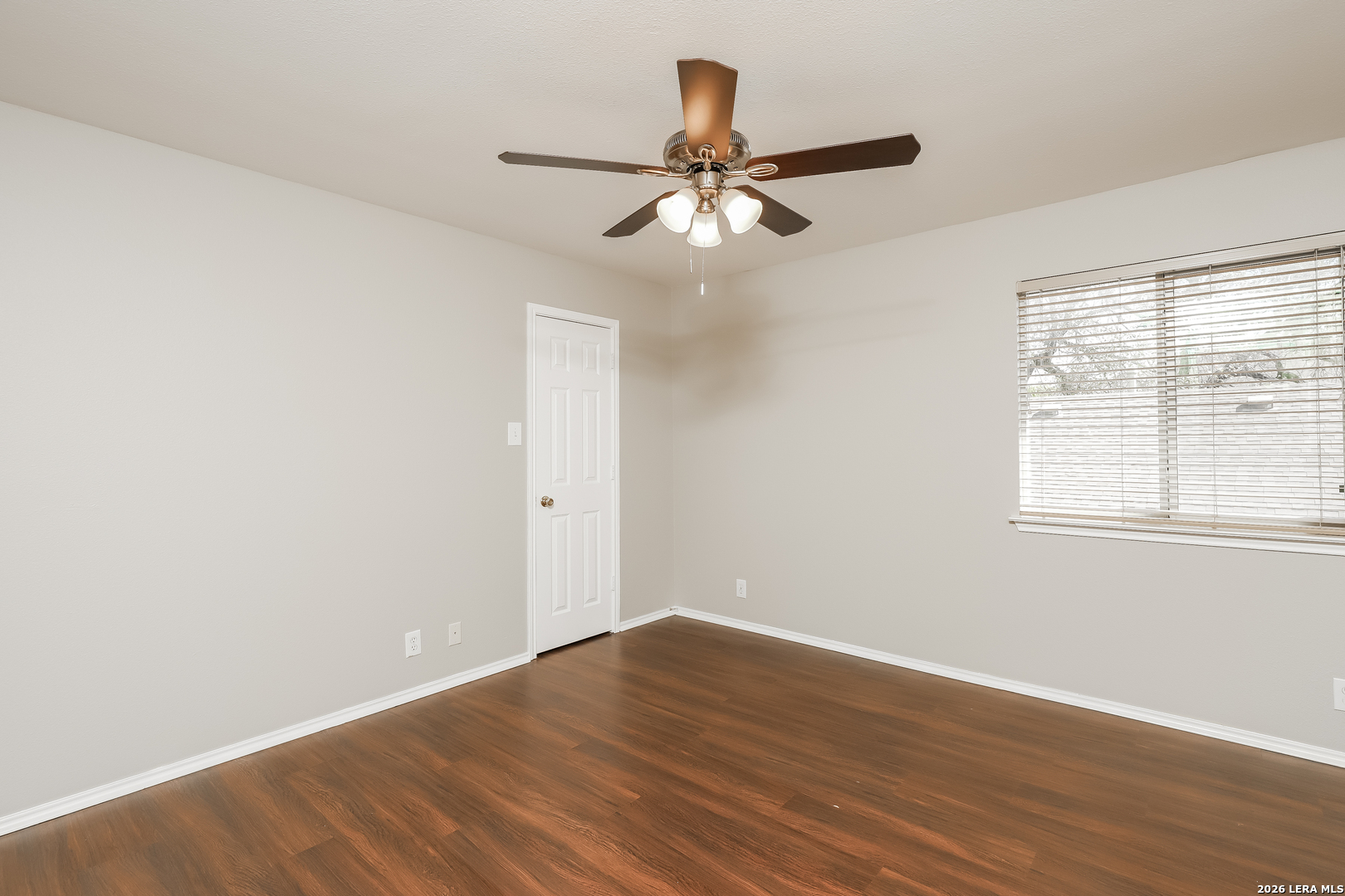 8611 Tioga Pass Helotes, TX 78023 - Photo 12 of 14 an empty room with wooden floor fan and windows