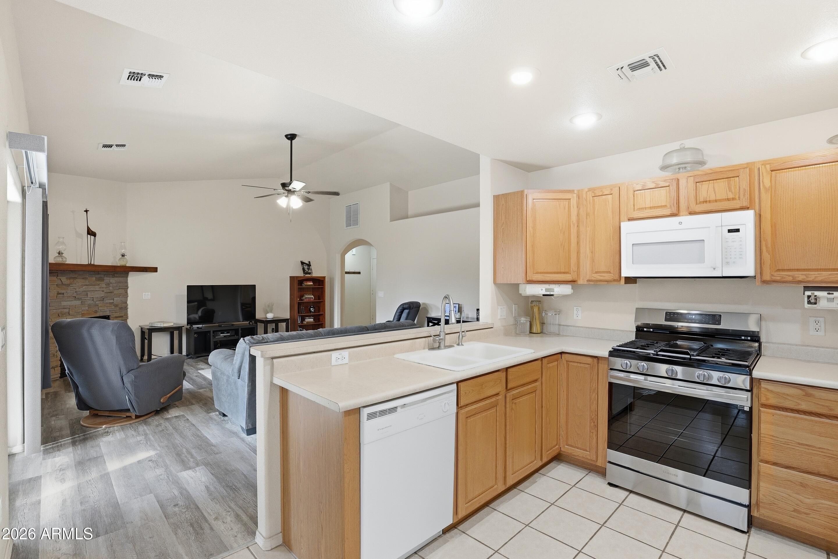 913 Landmark Trail Payson, AZ 85541 - Photo 13 of 47 a kitchen with stainless steel appliances granite countertop a stove top oven a sink dishwasher a dining table and chairs with wooden floor