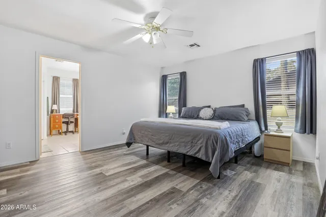 a bedroom with a large bed a chandelier and windows