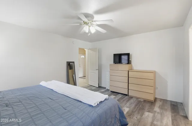 a bedroom with a bed and a ceiling fan