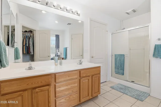 a bathroom with a double vanity sink mirror and shower