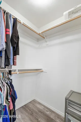a view of walk in closet with clothes and shoes