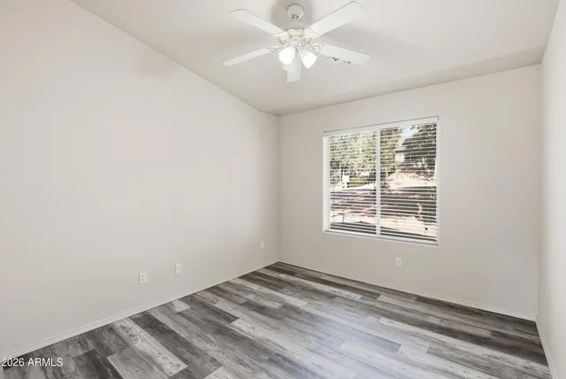an empty room with a window and a fan