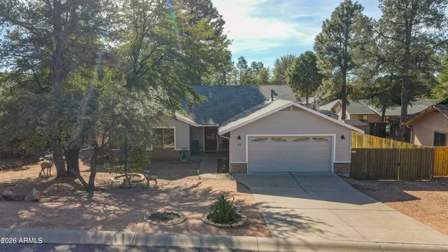 a view of a yard in front of a house with large tree