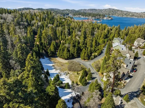an aerial view of a house with a yard and lake view