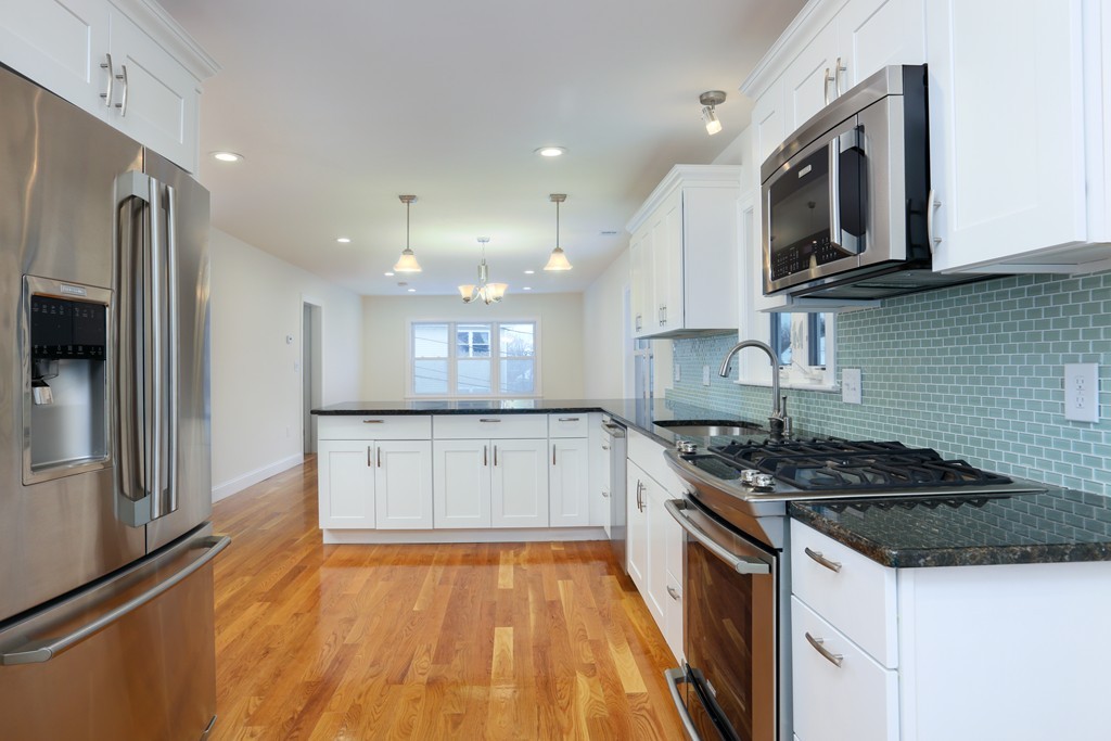 a kitchen with granite countertop a stove top oven and cabinets