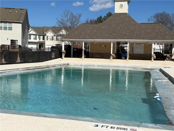 a view of a white house with a swimming pool