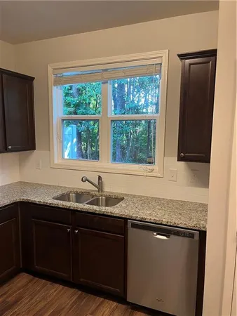 a kitchen with granite countertop kitchen island a sink appliances and a window