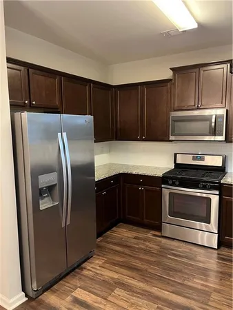 a kitchen with a refrigerator sink and cabinets