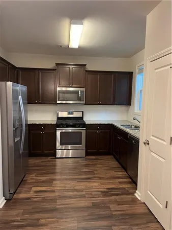 a kitchen with kitchen island granite countertop a stove and a refrigerator