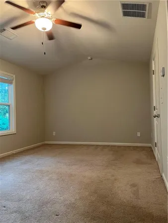 an empty room with a window and a fan