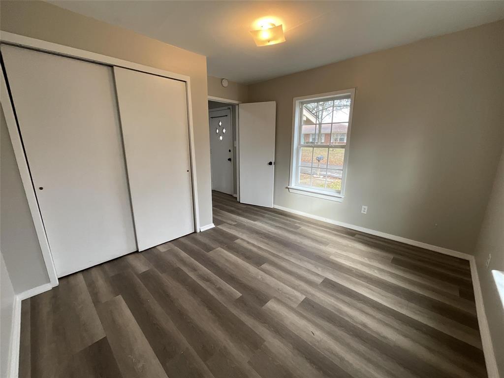 405 Beard Street Canton, TX 75103 - Photo 3 of 20 a view of an empty room with wooden floor and a window