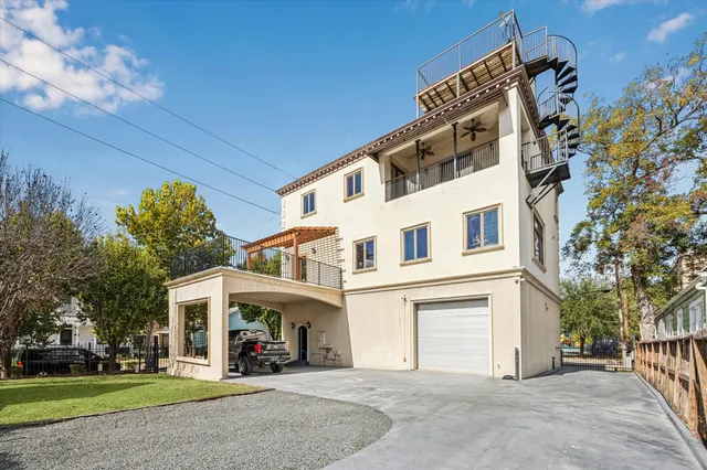 a view of a white house with a large windows and a yard