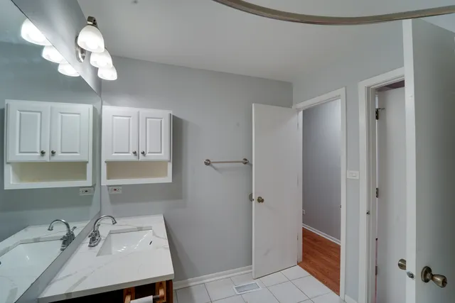 a bathroom with a sink a light fixture and a mirror