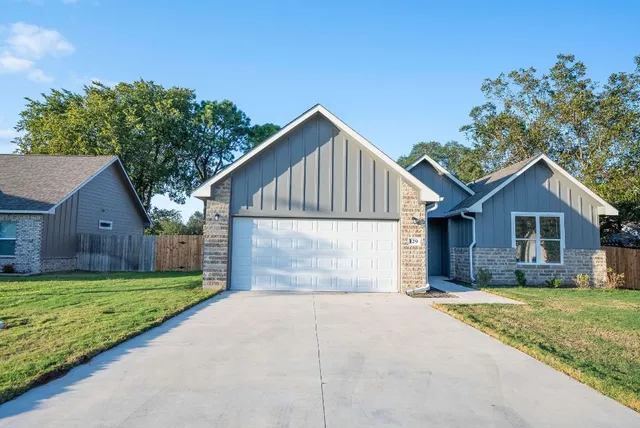 a front view of house with yard and garage
