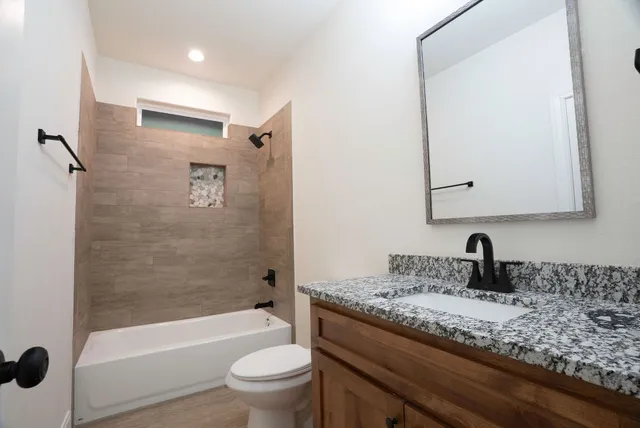 an empty room with chandelier fan and windows