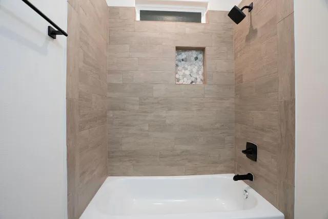 a bathroom with a granite countertop sink a toilet a mirror a vanity and bathtub