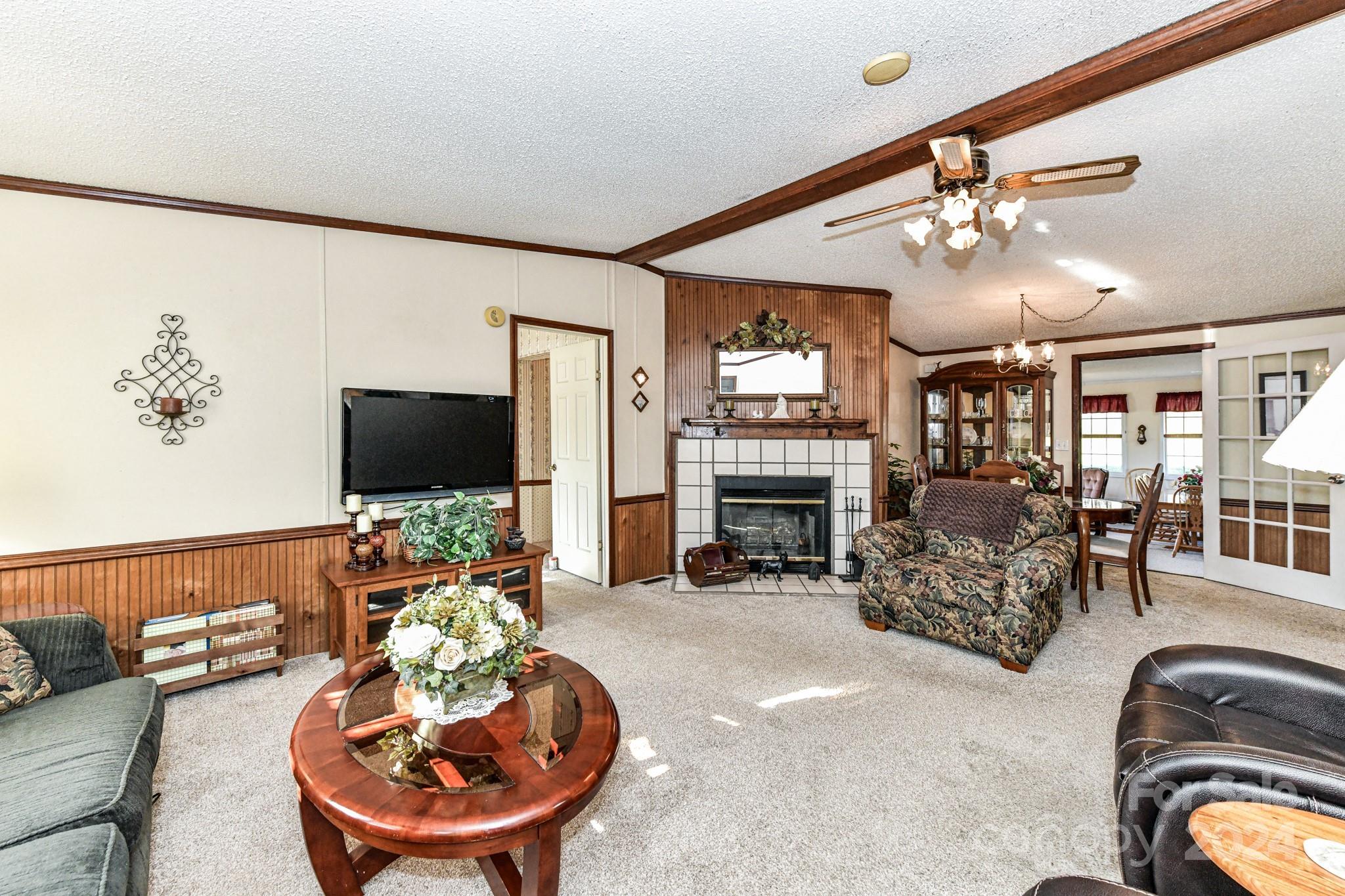 717 Clontz Long Road Monroe, NC 28110 - Photo 13 of 35 a living room with furniture a fireplace and a flat screen tv