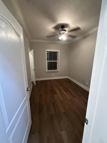 a view of empty room with wooden floor