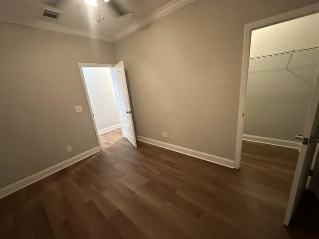 an empty room with wooden floor and white walls
