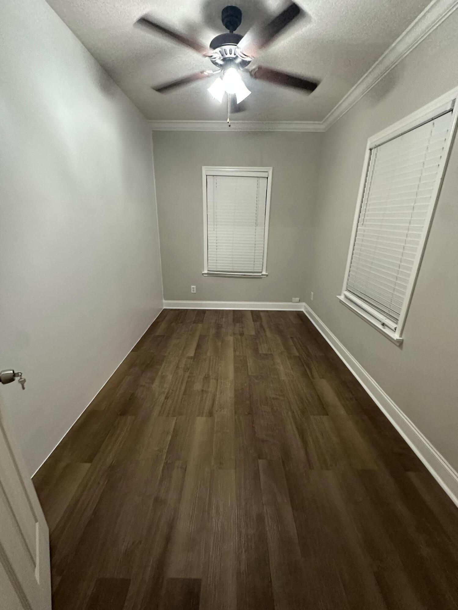 30964 Nathalie Road Big Pine Key, FL 33043 - Photo 9 of 10 an empty room with wooden floor fan and windows