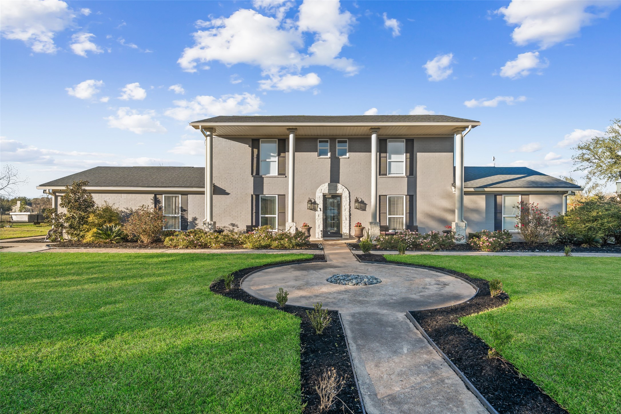 Impressive estate style frontage showcasing expansive grounds, circular walkway, and stately curb appeal.